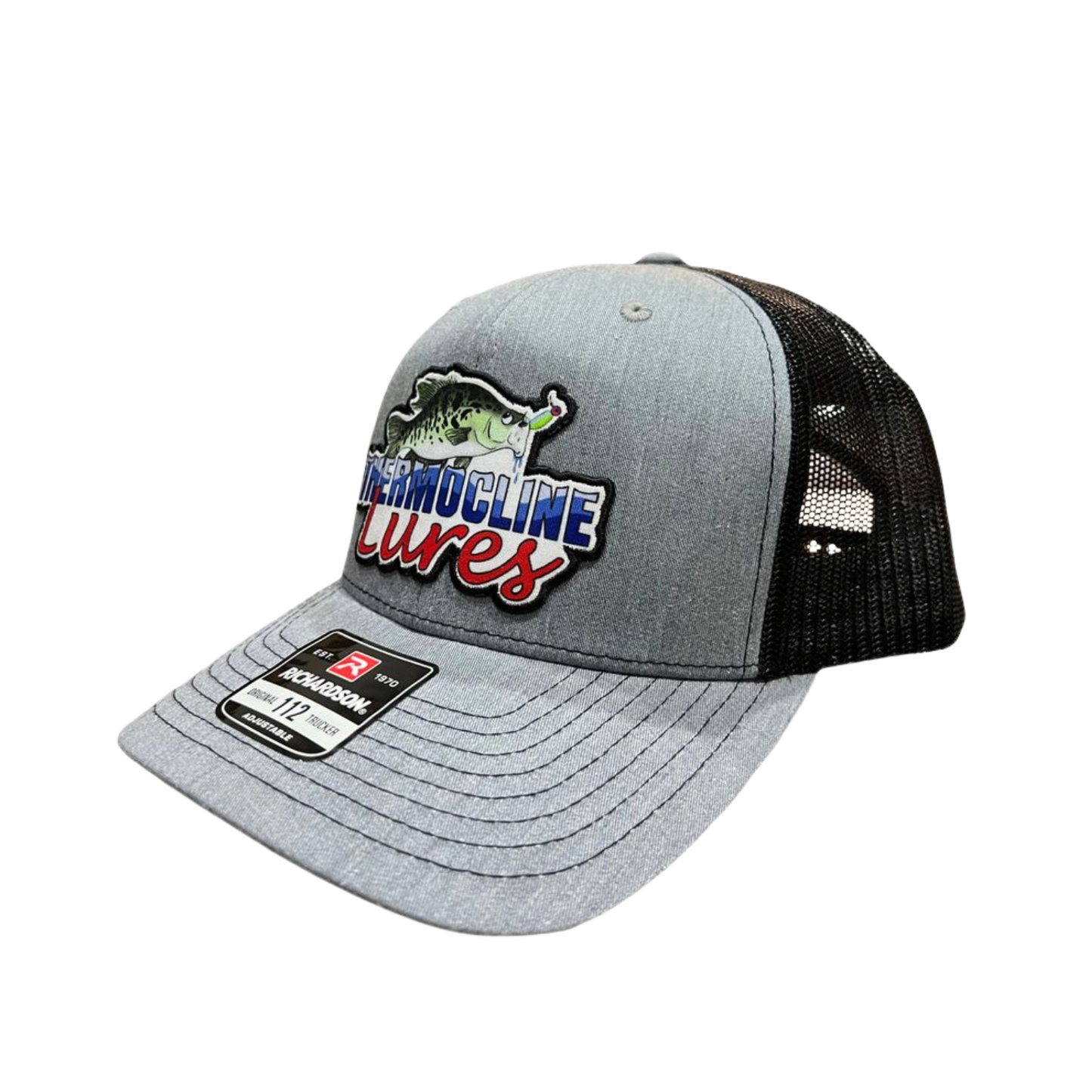 Left side view of the Thermocline Lures Grey and Black Richardson 112 Trucker Hat, featuring an embroidered Thermocline patch.