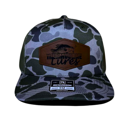 Front view of the Moss Duck Camo Light Green Thermocline Lures hat with a brown leather patch logo and light camo design.