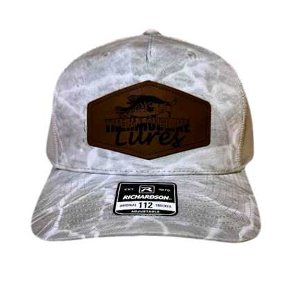 Front profile of the Thermocline Lures gray Mossy Oak Break-Up Infinity camo trucker hat featuring a brown leather patch logo. Classic outdoor style.