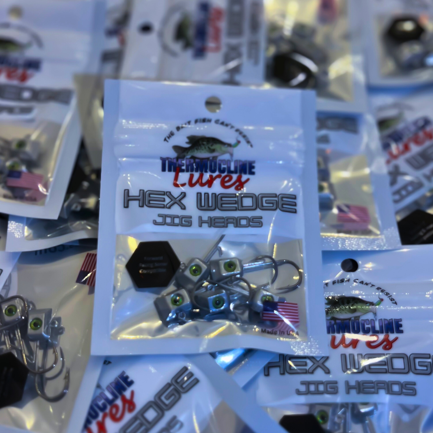 Thermocline Lures Hex Wedge Jig Heads in retail packaging. The clear-front resealable bag showcases chrome jig heads with green 3D eyes, emphasizing their precision design and fishing performance.