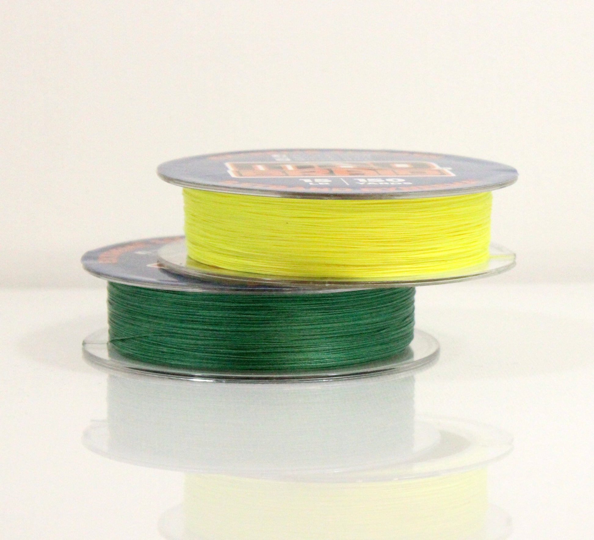 Two spools of Mad Braid braided fishing line stacked, displaying bright chartreuse and moss green colors for versatility in different water conditions.